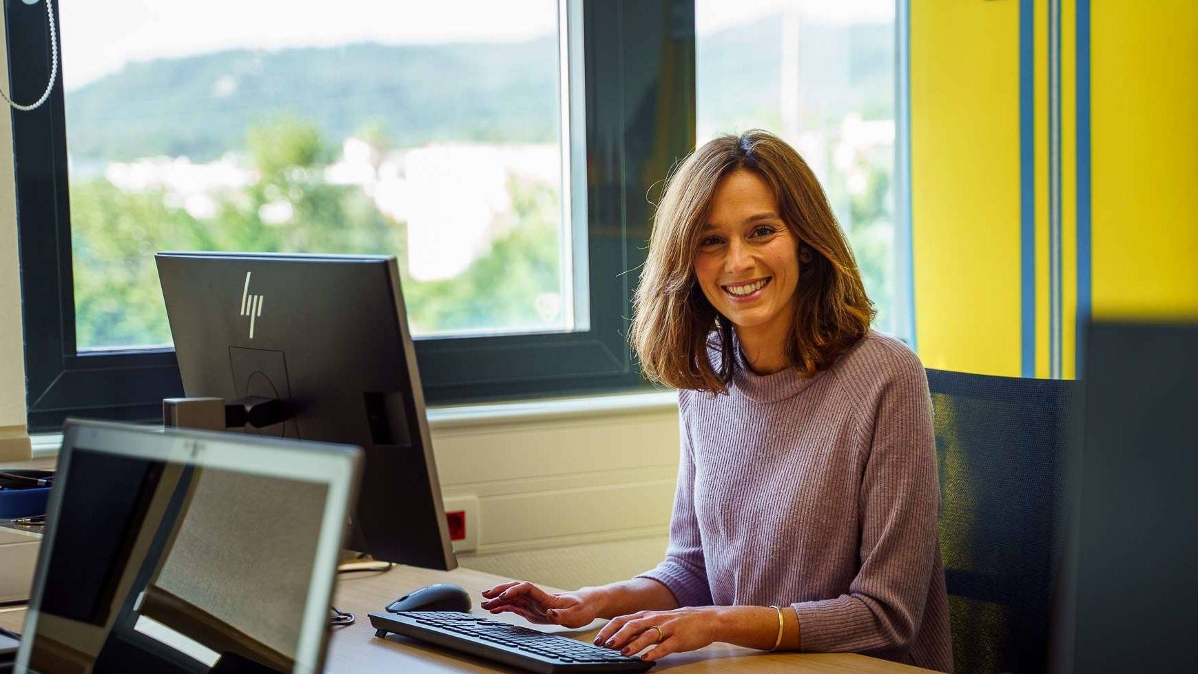 Colaboradora de comunicação a trabalhar ao computador